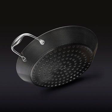 The underside of the HexClad 12&quot Hybrid BBQ Grill Pan on a black background